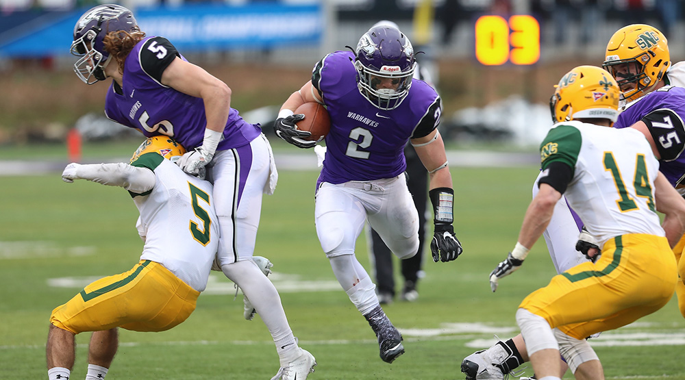 Ronny Ponick hurdles through a hole against St. Norbert. (Photo by Steve Frommell, d3photography.com)